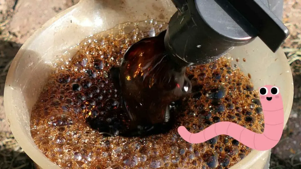 Photo of worm tea being poured into a bucket and a smiley worm drawing on top.